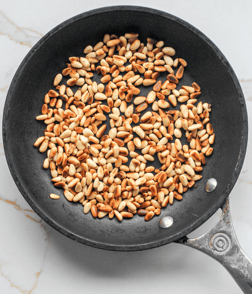 pan with pine nuts for a pearl couscous salad