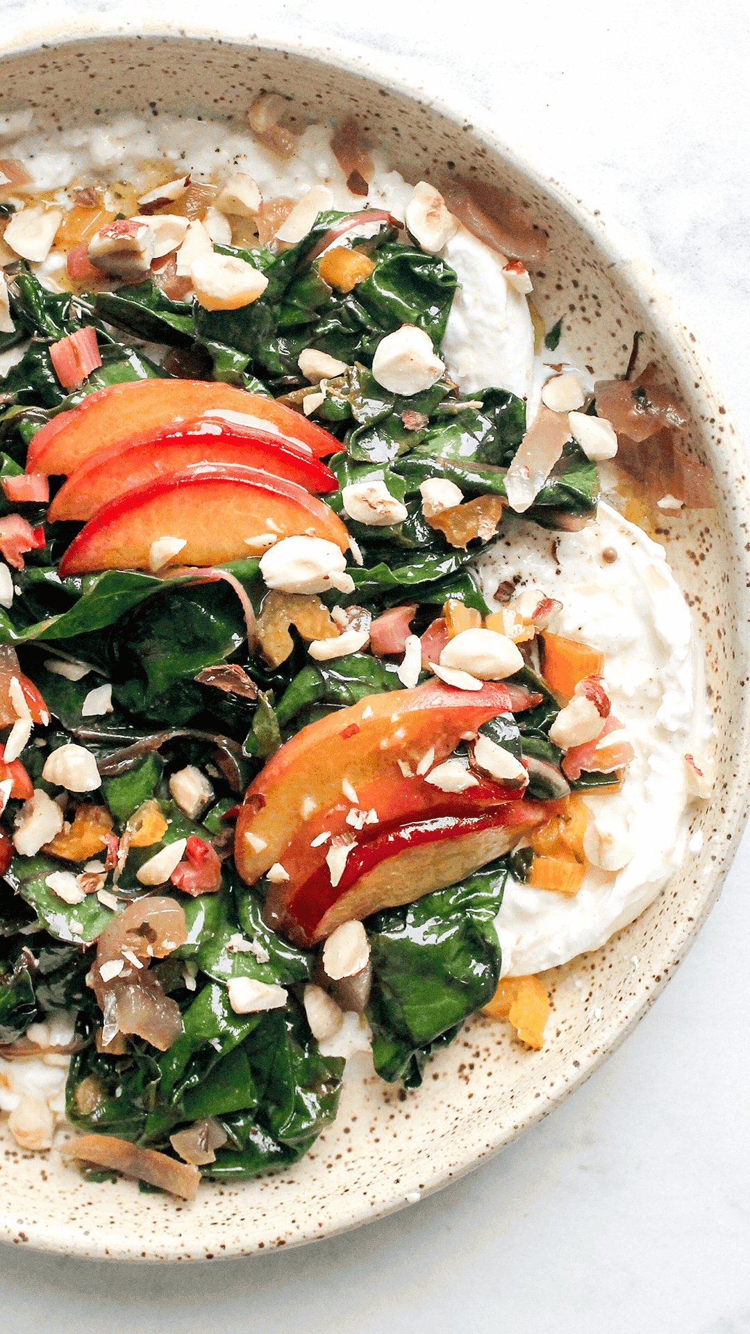 close of photo of peach and burrata salad in a plate