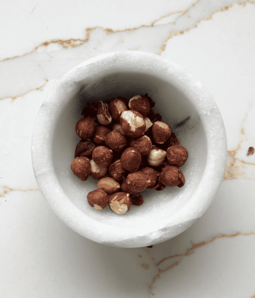 mortar and pestle with hazelnuts in it