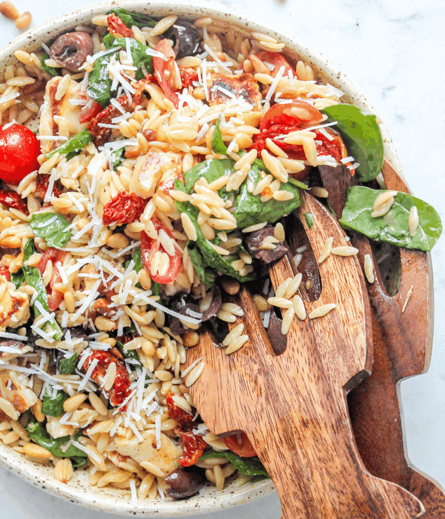 bowl and tongs of Mediterranean Orzo Salad