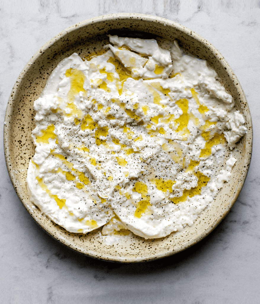 a bowl with burrata and olive oil in it