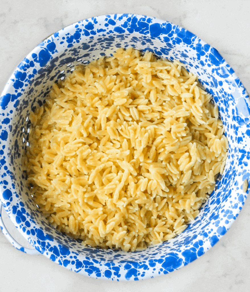 bowl of orzo in strainer for mediterranean orzo salad