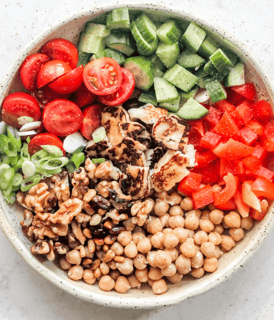 ingredients in a bowl for chickpea and halloumi salad