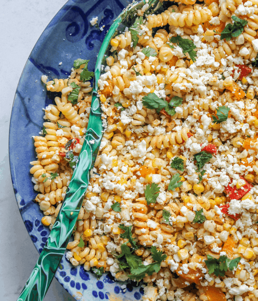 close up of spoon and bowl of Elote pasta salad
