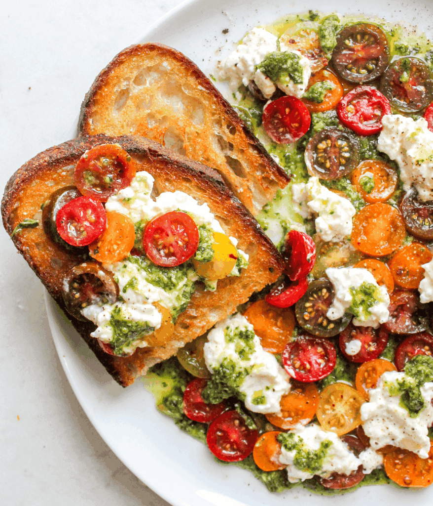 bread and plate of pesto tomato and burrata