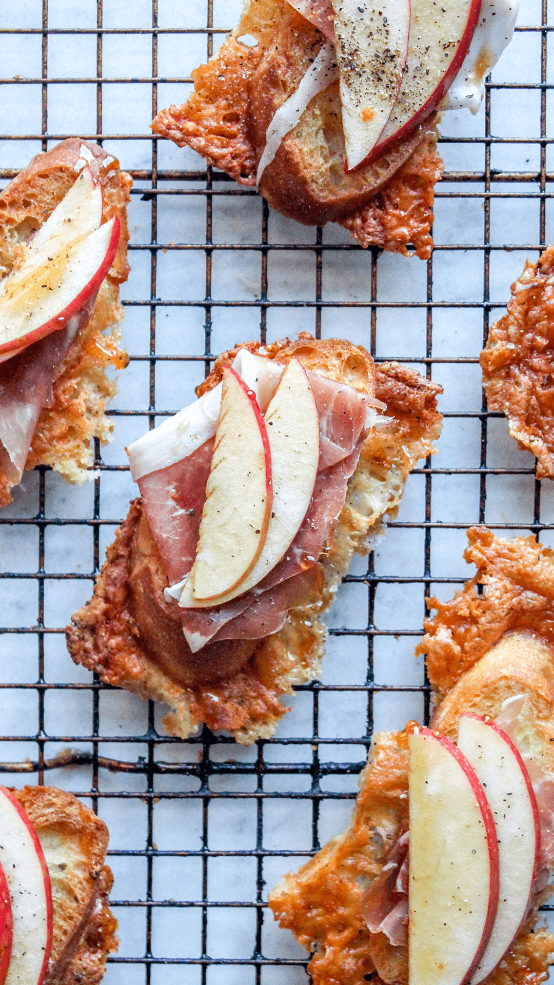Asiago crusted crostini with apples and prosciutto