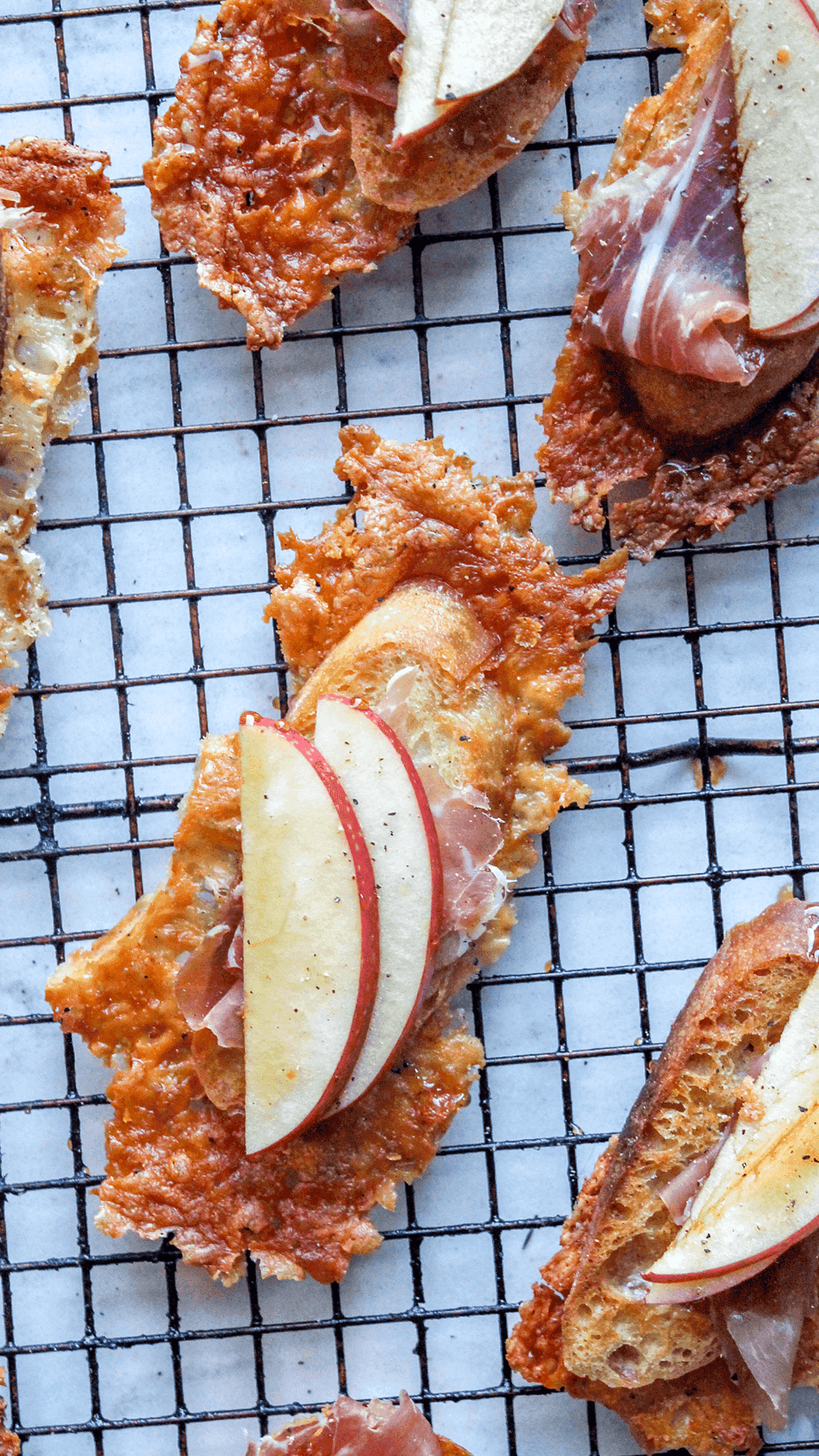 Asiago crusted crostini with apples and prosciutto