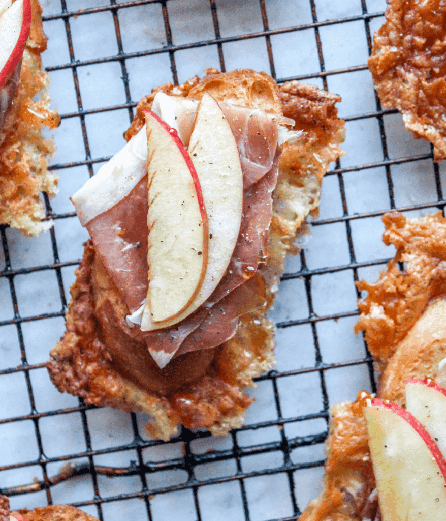Asiago crusted crostini with apples and prosciutto