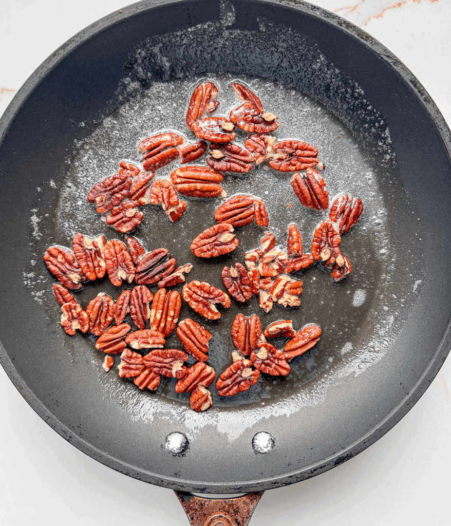 pecans cooking in butter in a nonstick skillet. 